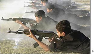 Iraqi schoolboys practise firing assault rifles at a summer military camp.