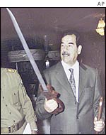 Saddam Hussein inspects a sword he received for his 65th birthday on 10 August 2002.