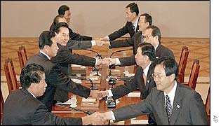 South Korean delegates (L) shake hands with their North Korean counterparts (R