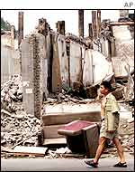 A man walks past a demolished neighbourhood in Beijing