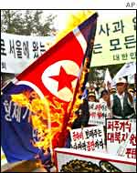 A flag is burnt at an anti-North Korean protest