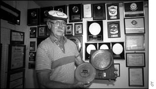 Ed Hendrick with a frisbee and its prototype, a Mother Frisbies pie tin