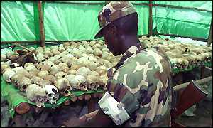 Soldier looks at bones of the genocide victims