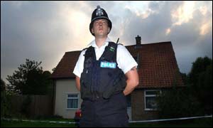 A policeman stands guard outside caretaker's home