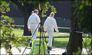 Forensic officers walking outside caretakers house at Soham Village College