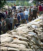 Hundreds of volunteers build embankments with sandbags 