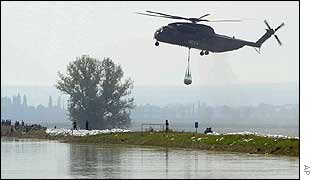 Helicopter drops sandbag on river bank near Torgau. AP