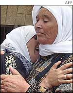 The mother of 13-year-old Mahmud Abu Oudeh cries on his grandmothers shoulder 