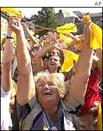 People in Wadowice wave scarves as the Pope flies over the town