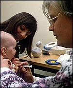 A doctor examines a baby in her surgery