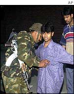 Indian soldier frisks civilians