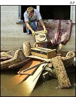 Woman removes debris from flooded house