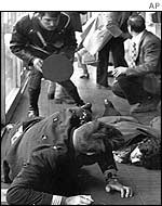 Two unidentified people lie injured on the floor of Rome's Fiumicino airport where guerrillas hijacked a plane iin 1973 