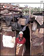 A woman stands outside her home made from materials found at a dump in Etipini township.