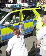 Woman jeers at police car