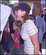 A woman screams abuse as a child looks on