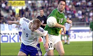 Goalscorer Robbie Keane forces his way past Hannu Tihinen