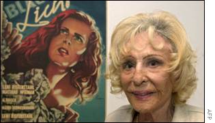 Leni Riefenstahl poses next to a poster for her film 