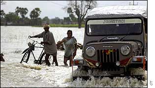 Indian villagers cross the flooded river Gandak