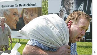 Man carries sandbag past posters of election candidates