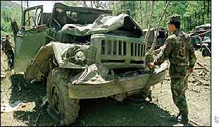Georgian soldier surveys bomb-damaged lorry in Pankisi Gorge
