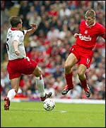 Liverpool's Steven Gerrard challenges Claus Lundekvam