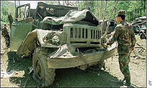 Georgian troops inspect a bombed-out military vehicle that was allegedly hit during the Russian raid. Moscow denies the claim.