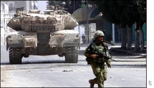 An Israeli soldier and patrolling tank in Nablus on Monday