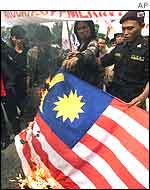 Indonesian protesters burn a Malaysian flag during a demonstration outside the Malaysian embassy in Jakarta 