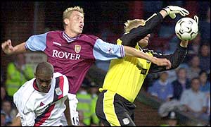 Aston Villa striker Peter Crouch challenges Man City keeper Peter Crouch