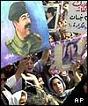 Iraqi crowd carries pictures of Saddam Hussein 