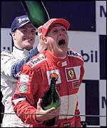 Ralf Schumacher pours champagne down Michael Schumacher's neck
