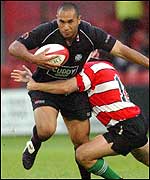 Dave Tiueti bursts through the tackle of Sam Cox