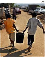 South African youths carrying water bucket