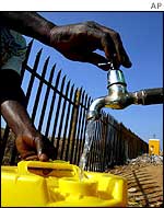 A woman collects water at a Johannesburg settlement