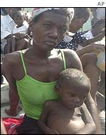Haitian mother waits for medical aid with her sick child