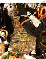 Workers take away the last beam of the World Trade Center in May