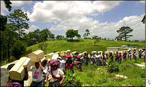 Guatemalans carry recently excavated remains of war victims