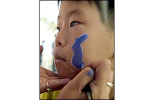 Korean child has his face painted ahead of the match