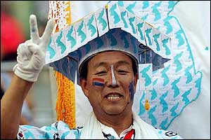 Korean fan wearing a homemade hat with the blue and white unification flag