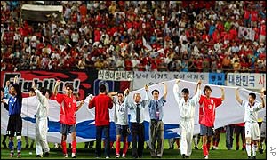North and South Korean players as well as coaching staff carry the unification flag 