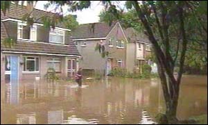 Man leaving flooded house