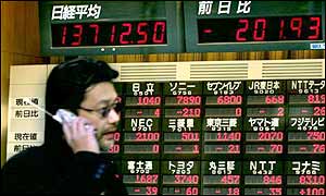 Man walking past stock market board 