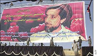 Afghan workers display a huge portrait of Ahmad Shah Masood at the sports stadium in Kabul