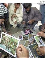 A group of Afghans look at photos of Masood