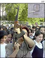 An Iraqi teacher fires an AK-47 to mark the beginning of school