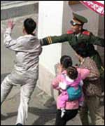 North Korean couple are grabbed by a Chinese guard as they attempt to rush through the Canadian embassy gates in Beijing