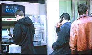 People at a cash machine