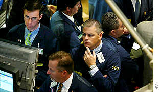 Traders and specialists check the monitors as they work on the floor at the New York Stock Exchange shortly after the opening bell on Tuesday.