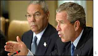 Colin Powell (background) and George W Bush